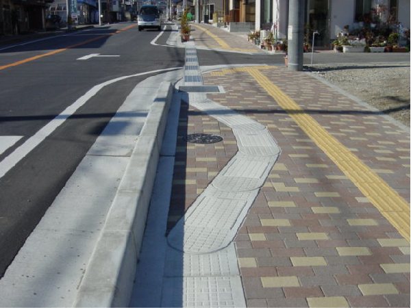歩道上で緩やかなS字を描いて設置されたフレキシブル側溝