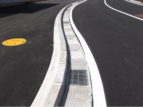 車道のカーブ部に設置されたフレキシブル側溝。グレーチング蓋を組み合わせている